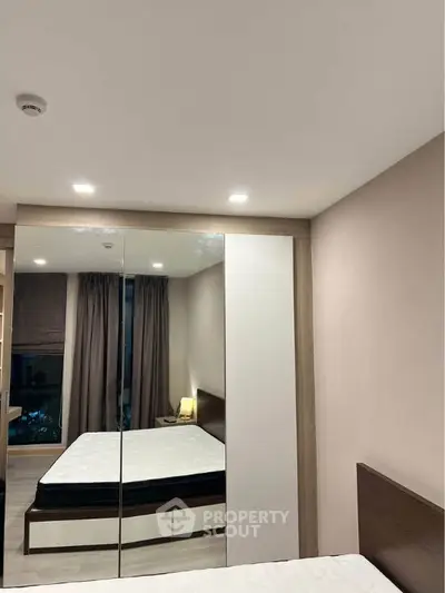 Modern bedroom with mirrored wardrobe and cozy lighting