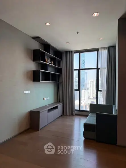 Modern living room with city view, featuring sleek shelving and stylish furniture.