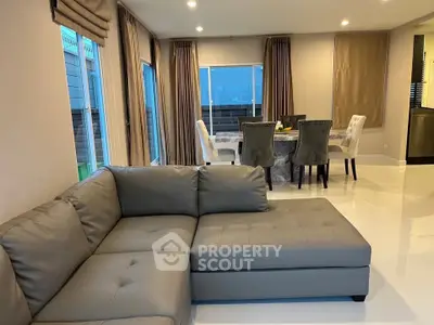 Spacious modern living room with elegant dining area and large windows for natural light.