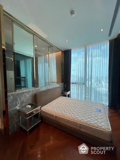 Luxurious bedroom with floor-to-ceiling windows and elegant decor in high-rise apartment.