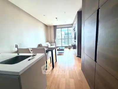 Modern living room with open kitchen and city view, featuring sleek wooden flooring and contemporary furniture.