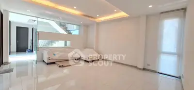 Spacious modern living room with elegant lighting and sleek tile flooring