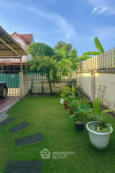 Charming garden with lush greenery and potted plants in a serene residential backyard.