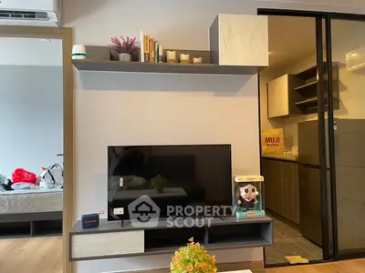 Modern living room with sleek TV setup and stylish shelving in a cozy apartment.