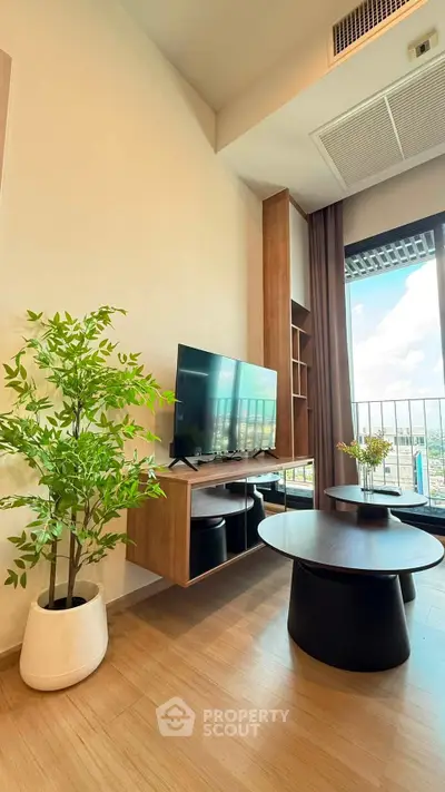 Modern living room with large TV, stylish furniture, and balcony view.