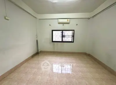Spacious empty room with tiled floor and air conditioning unit.