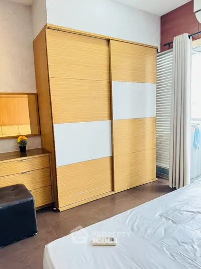 Modern bedroom with stylish wooden wardrobe and natural light