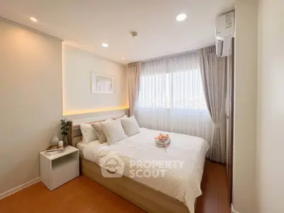 Cozy and bright bedroom with modern decor and large window for natural light.