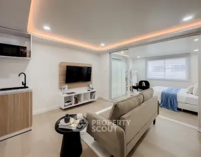 Modern open-concept living room with cozy sofa and sleek kitchenette