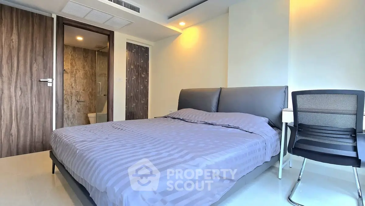 Modern bedroom with ensuite bathroom and sleek furnishings in a contemporary apartment.