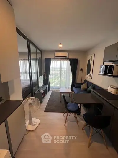 Modern open-plan living room with stylish decor and large windows offering natural light.