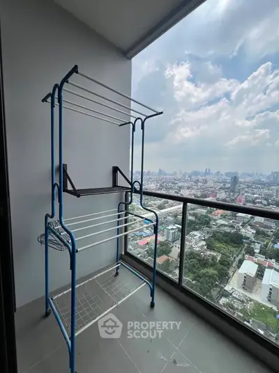 High-rise balcony with stunning cityscape view and drying rack