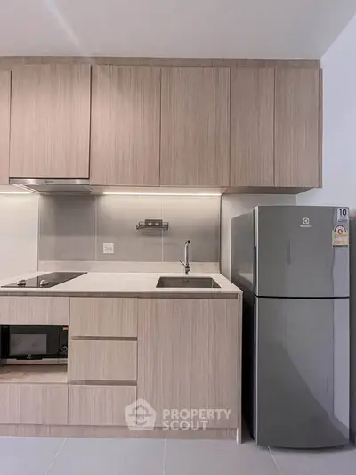Modern kitchen with sleek cabinetry and stainless steel appliances in a stylish apartment.