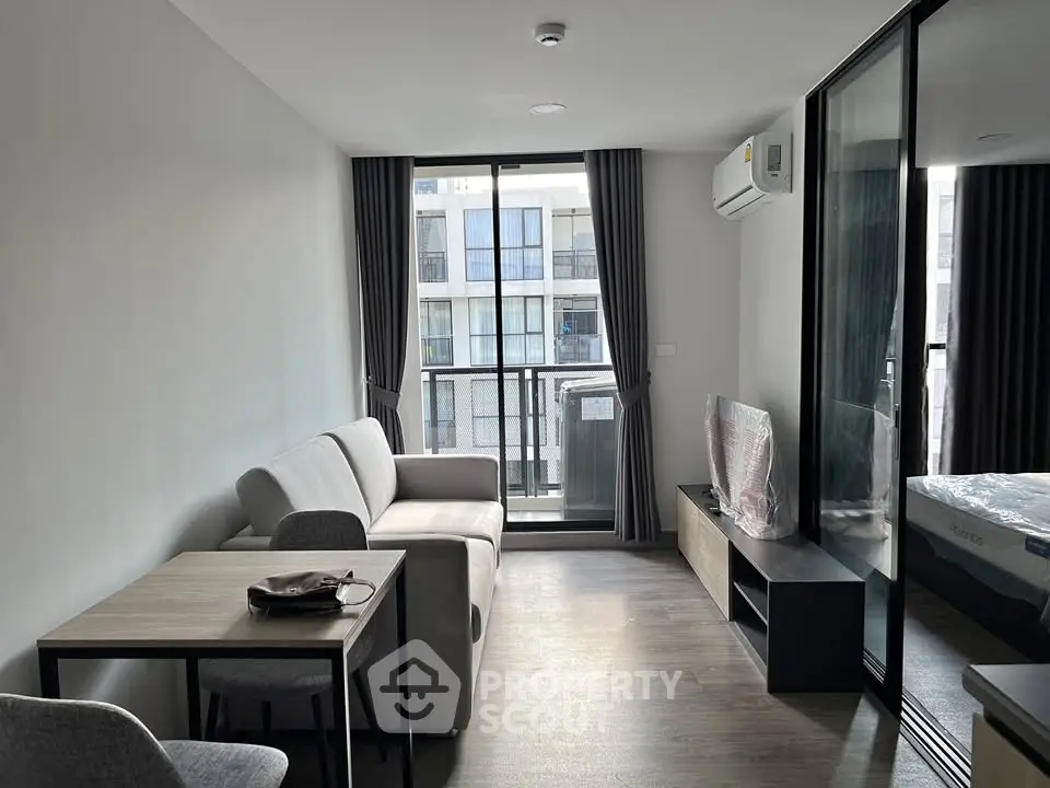 Modern living room with sleek furniture and large window in a stylish apartment.