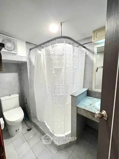 Compact bathroom with shower curtain and modern fixtures