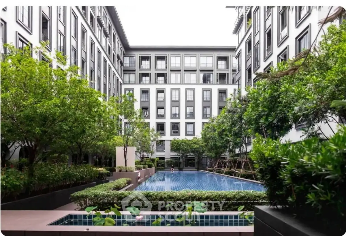 Luxurious residential complex with serene pool and lush greenery