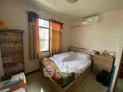 Cozy bedroom with natural light and air conditioning, perfect for relaxation.