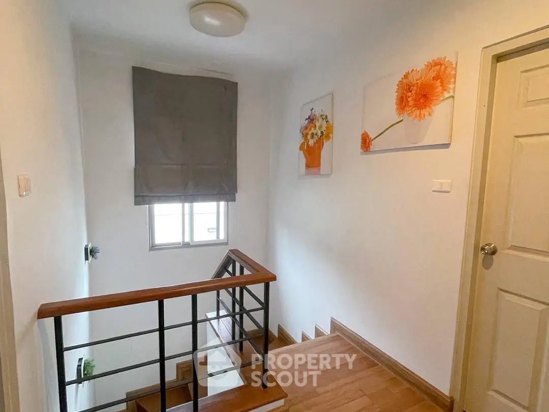 Charming staircase with wooden steps and floral artwork in a cozy home interior.