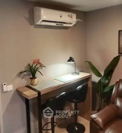 Cozy study nook with modern desk, chairs, and air conditioning in stylish apartment.