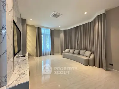 Spacious modern living room with elegant marble accents and cozy seating area.