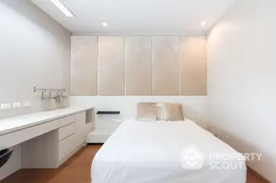 Sleek modern bedroom with built-in wardrobes and integrated workspace, perfect for urban living.