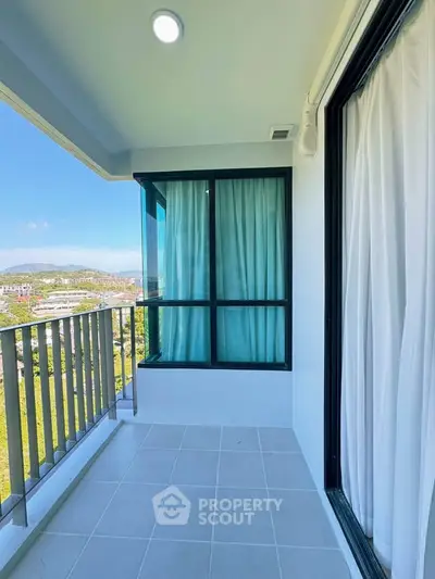 Spacious balcony with stunning view and modern design in high-rise apartment.