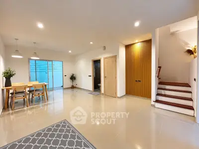Spacious modern living room with dining area and elegant staircase