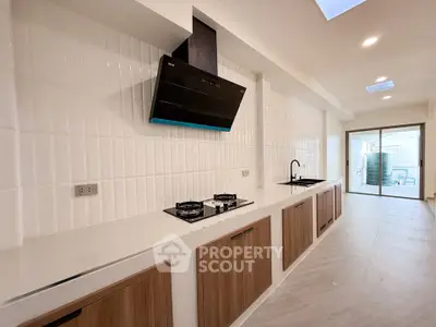Spacious modern kitchen with sleek gas stove and ample cabinetry in a bright open layout.