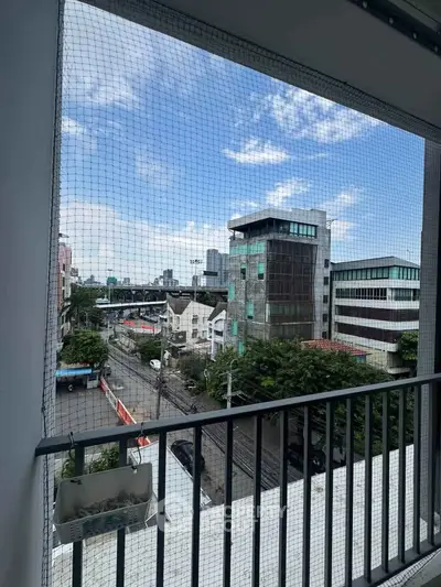 Urban balcony view with cityscape and blue sky, perfect for city living enthusiasts.