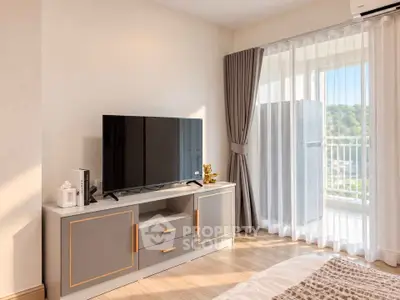 Modern bedroom with stylish TV stand and large window offering scenic views.