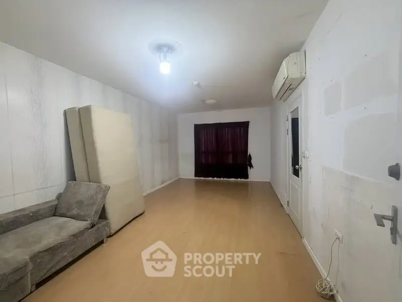 Spacious unfurnished room with air conditioning and wooden flooring