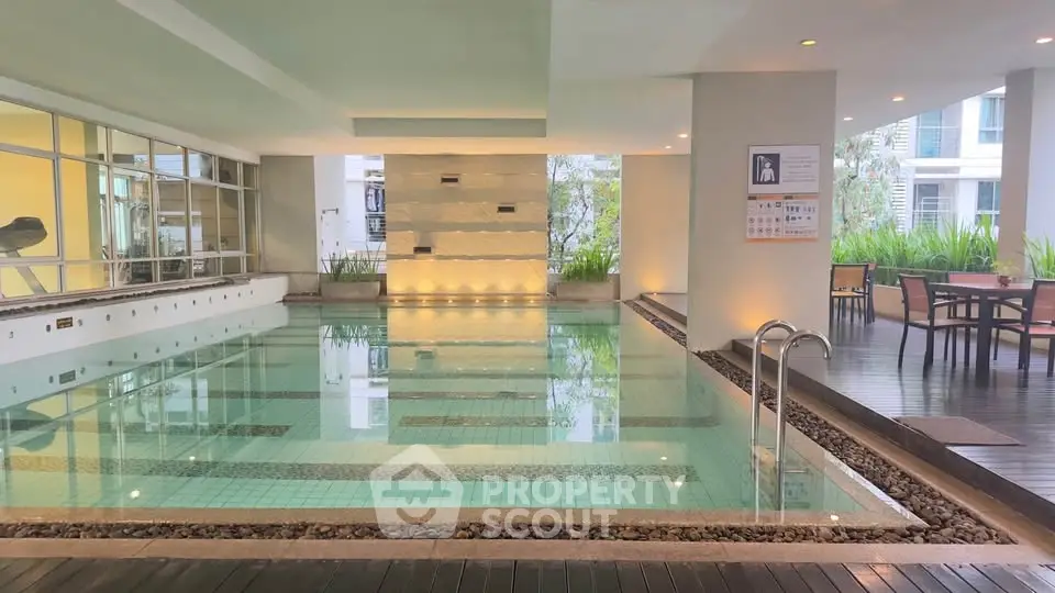 Luxurious indoor pool area with modern design and ambient lighting in a high-end residential complex.