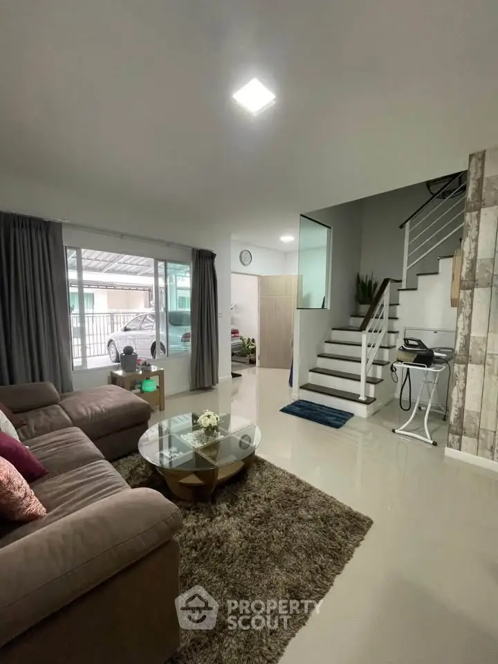 Spacious living room with modern decor and staircase in a stylish home