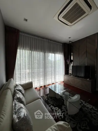 Luxurious living room with modern furniture and large windows offering natural light.