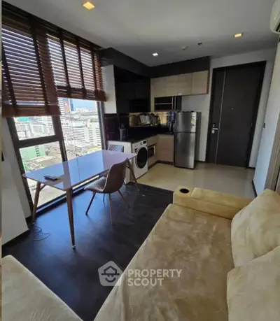 Modern studio apartment with city view, featuring compact kitchen and cozy living area.
