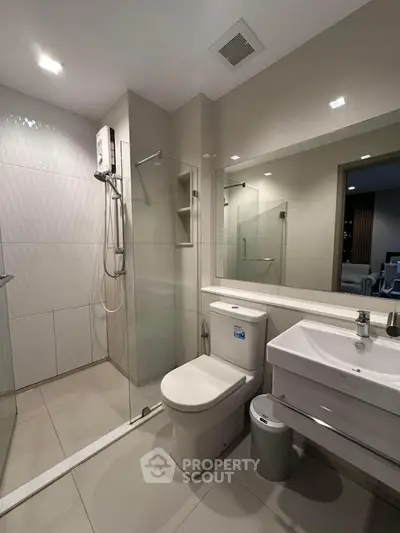 Modern bathroom with glass shower and sleek fixtures in a contemporary home.