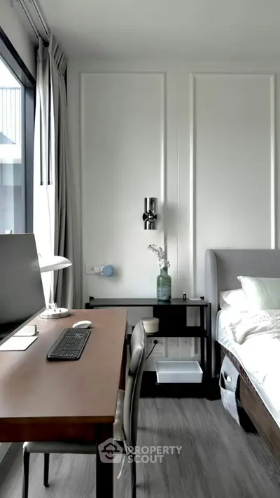 Modern bedroom with sleek desk and large window, perfect for work and relaxation.