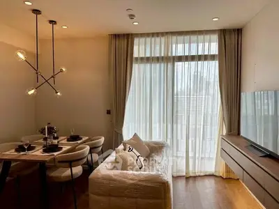 Modern living room with elegant dining area and large window with sheer curtains.
