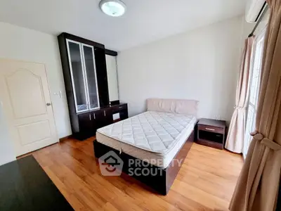 Spacious bedroom with wooden flooring and large wardrobe, perfect for comfort and style.