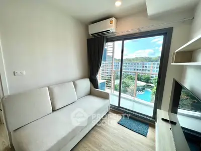 Modern living room with pool view and balcony access in a stylish apartment.