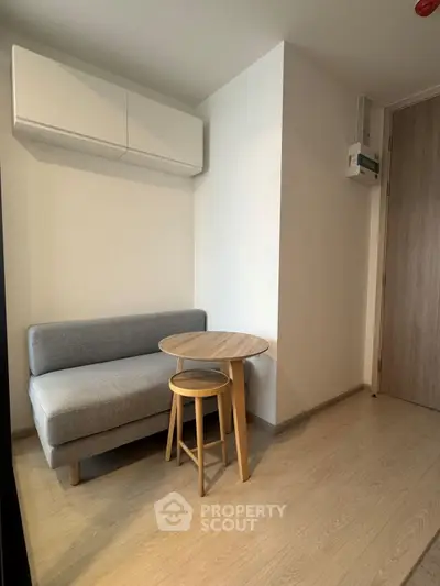 Cozy corner with modern sofa and wooden table in a minimalist apartment interior.