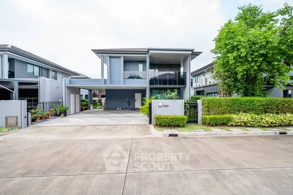 Modern two-story house with sleek design and spacious driveway in a serene neighborhood.