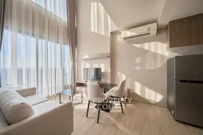 Modern living room with high ceilings and large windows offering stunning views.