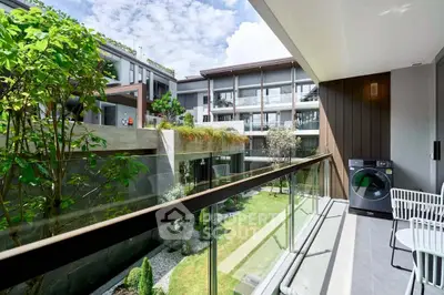 Modern apartment balcony with garden view and washing machine, perfect for urban living.