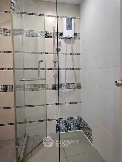 Modern bathroom with glass shower enclosure and stylish tile design.