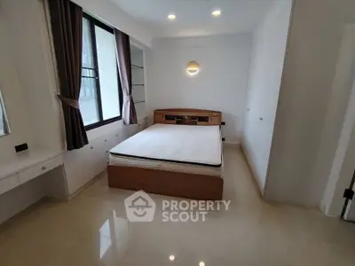 Spacious bedroom with modern design and natural light, featuring a comfortable bed and elegant furnishings.