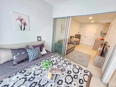 Modern studio apartment with stylish decor and sliding glass doors separating bedroom and living area.