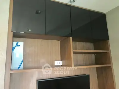 Modern wooden shelving unit with sleek black cabinets in a stylish living room.