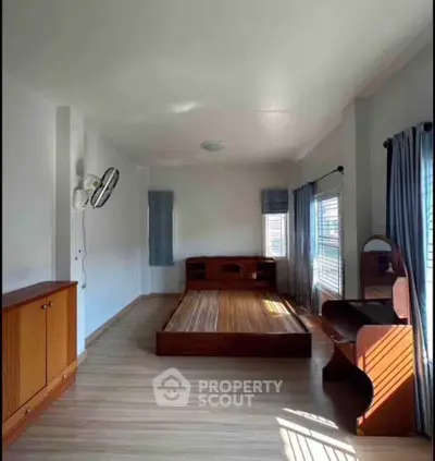 Spacious bedroom with wooden furniture and natural light