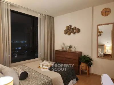 Cozy bedroom with city view, modern decor, and warm lighting for a relaxing ambiance.